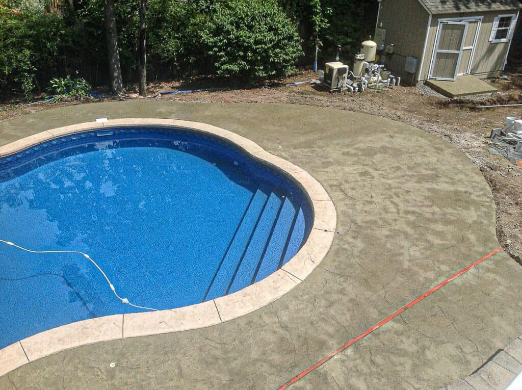 White pool coping bordering an in-ground pool.